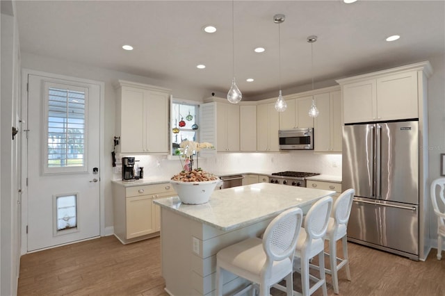 kitchen featuring white cabinets, pendant lighting, stainless steel appliances, and a kitchen island