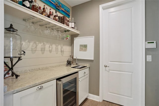 bar with white cabinetry and beverage cooler