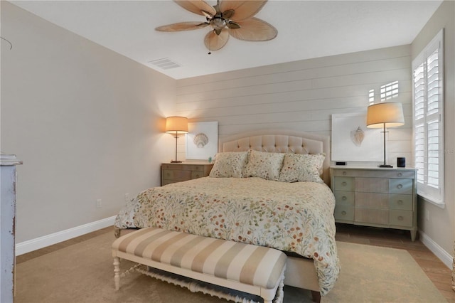 bedroom featuring ceiling fan, light hardwood / wood-style flooring, and multiple windows