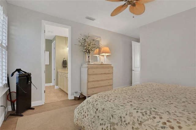 bedroom with ceiling fan, connected bathroom, and light hardwood / wood-style flooring