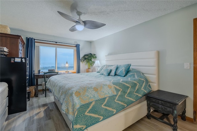 bedroom featuring hardwood / wood-style floors, a textured ceiling, and ceiling fan