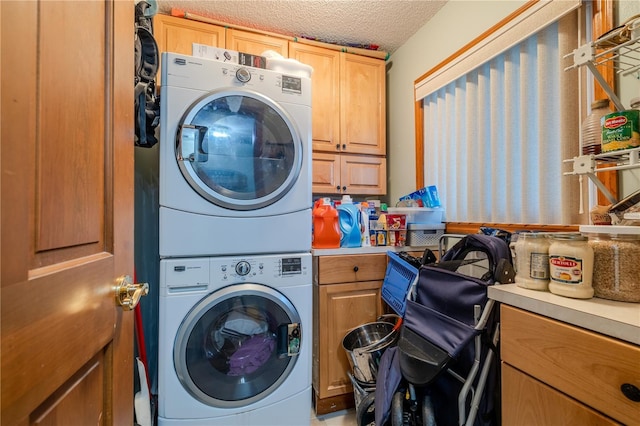 washroom featuring cabinets, a textured ceiling, and stacked washer / dryer