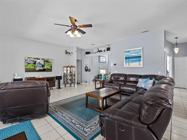 tiled living room featuring ceiling fan and a textured ceiling