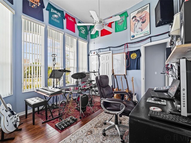 home office with ceiling fan and dark hardwood / wood-style floors