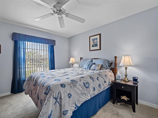 carpeted bedroom featuring ceiling fan and a textured ceiling