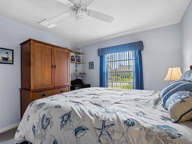 carpeted bedroom with ceiling fan and a textured ceiling