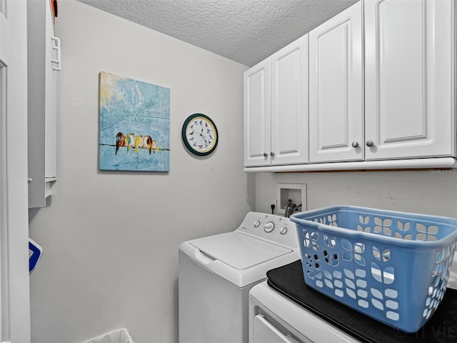 laundry area featuring separate washer and dryer, cabinets, and a textured ceiling