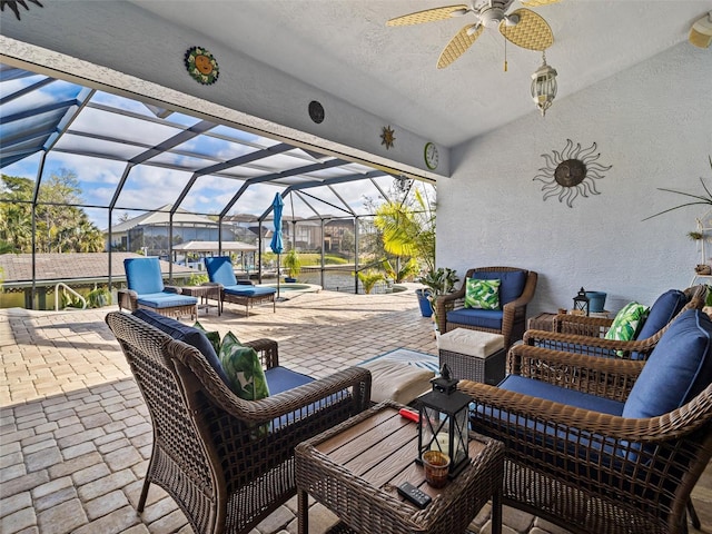 view of patio / terrace featuring outdoor lounge area, glass enclosure, and ceiling fan