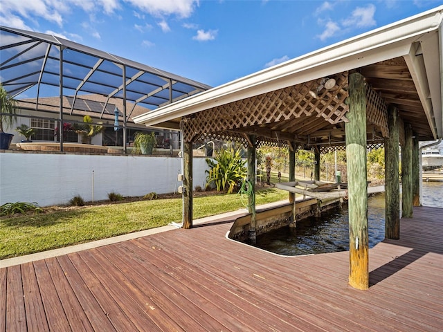 dock area with a water view, glass enclosure, and a lawn