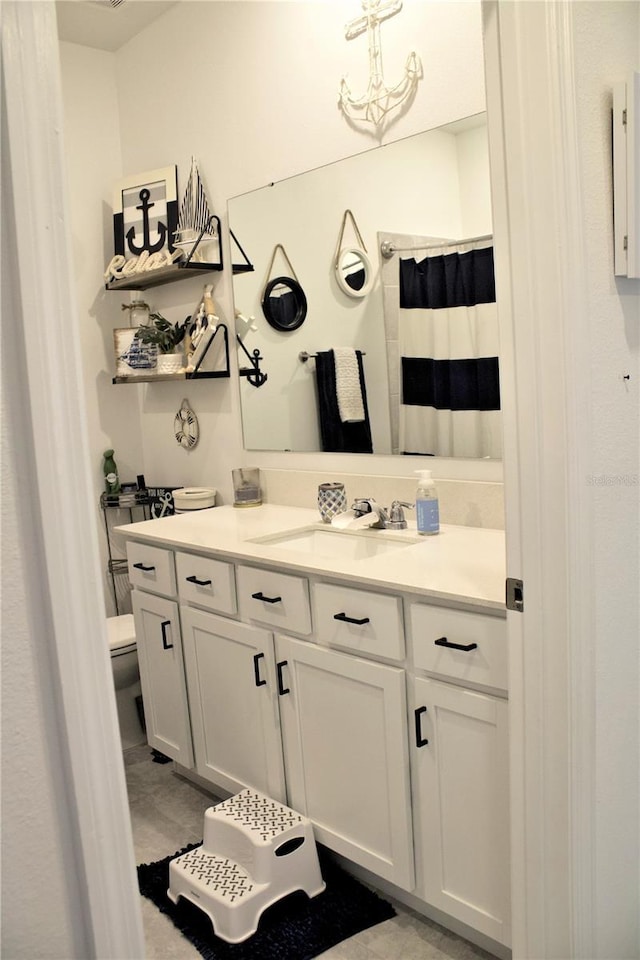 bathroom featuring a shower with curtain, tile patterned flooring, vanity, and toilet