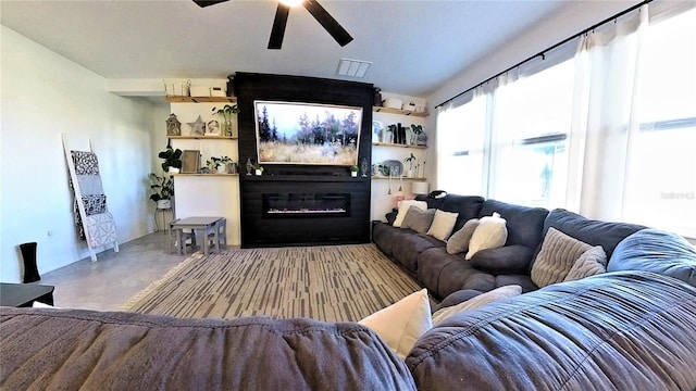 living room featuring ceiling fan and a large fireplace