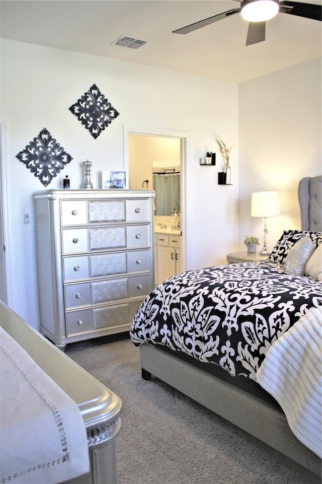 bedroom featuring dark colored carpet, ceiling fan, and ensuite bath