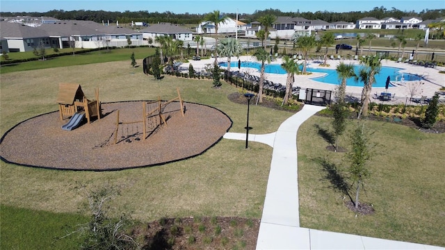 view of property's community with a yard and a swimming pool