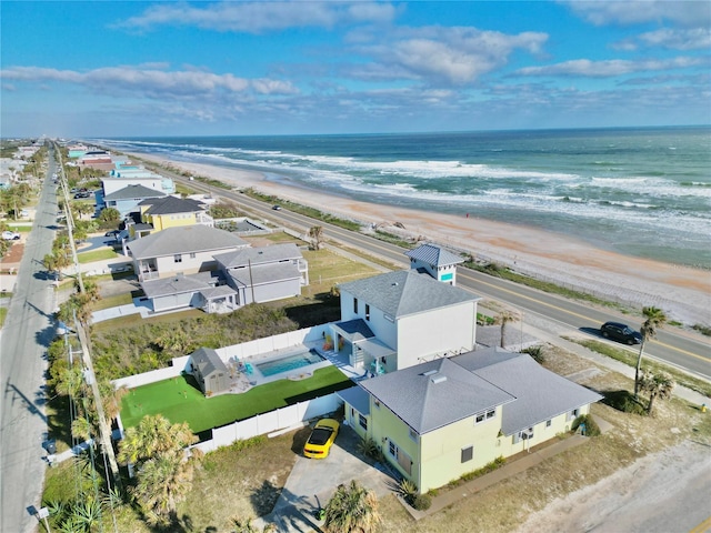 birds eye view of property featuring a water view and a beach view