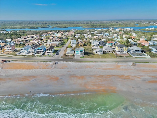 birds eye view of property featuring a water view and a beach view