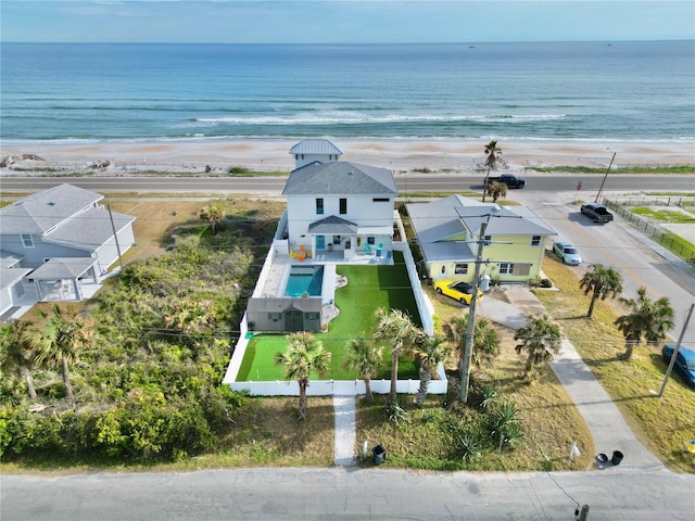 drone / aerial view featuring a water view and a view of the beach