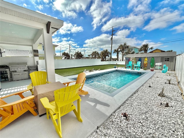 view of pool featuring area for grilling, a patio area, and exterior kitchen