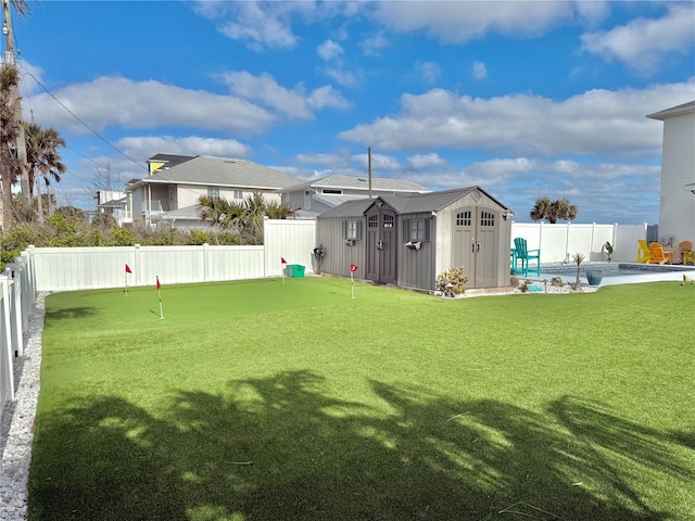 view of yard with a swimming pool and a storage shed