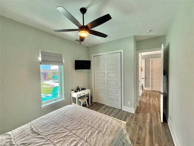 bedroom featuring ceiling fan, a closet, and dark wood-type flooring