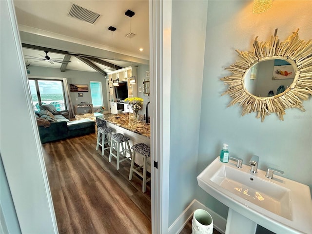 bathroom with ceiling fan, sink, beamed ceiling, and hardwood / wood-style flooring