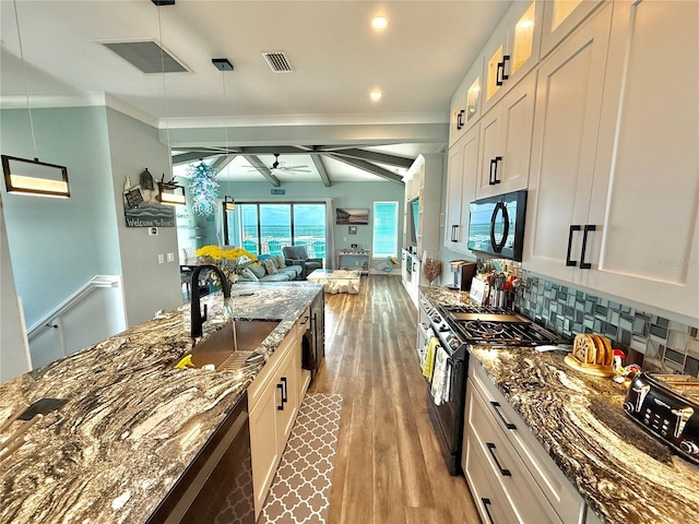 kitchen featuring sink, ceiling fan, dark stone countertops, appliances with stainless steel finishes, and white cabinetry