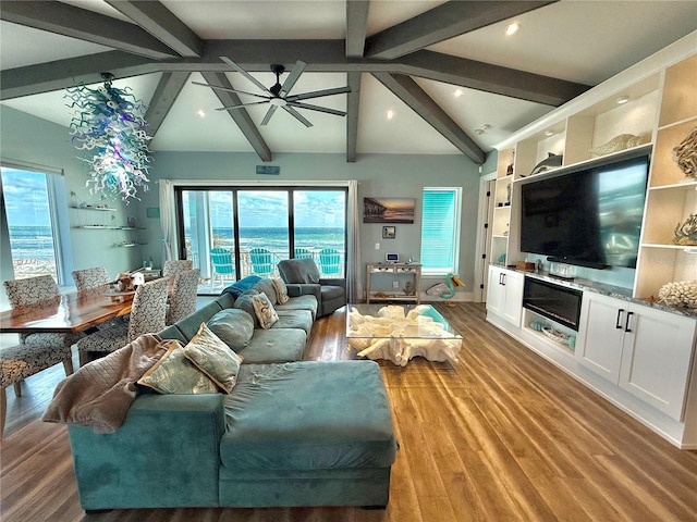 living room featuring vaulted ceiling with beams, ceiling fan, a water view, and hardwood / wood-style flooring