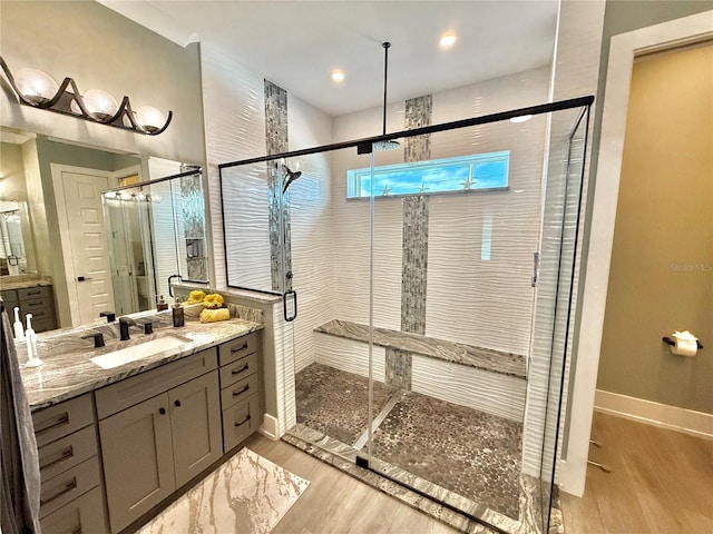 bathroom with vanity, an enclosed shower, and hardwood / wood-style flooring