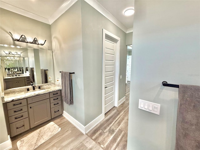 bathroom with hardwood / wood-style floors, vanity, and crown molding