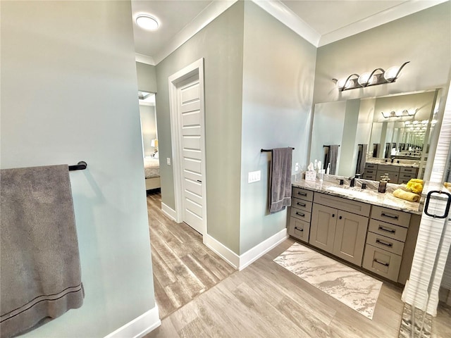 bathroom featuring hardwood / wood-style flooring, vanity, and ornamental molding