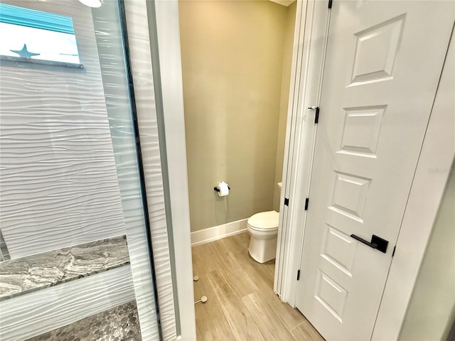 bathroom with toilet and wood-type flooring