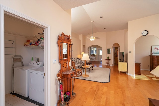 interior space with ceiling fan, washer and dryer, and light hardwood / wood-style flooring