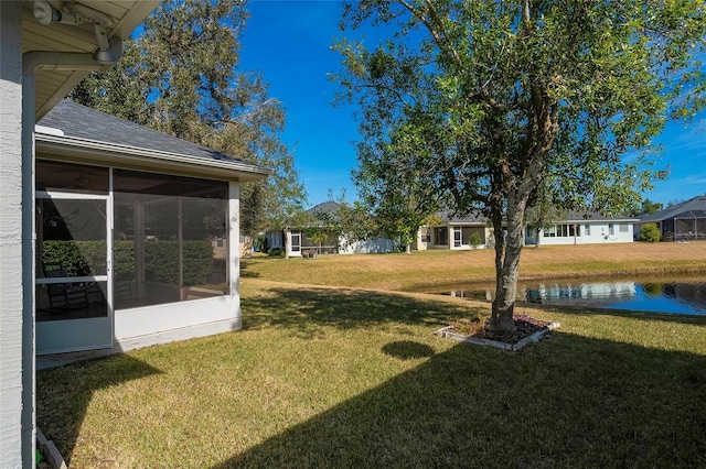 view of yard with a water view and a sunroom