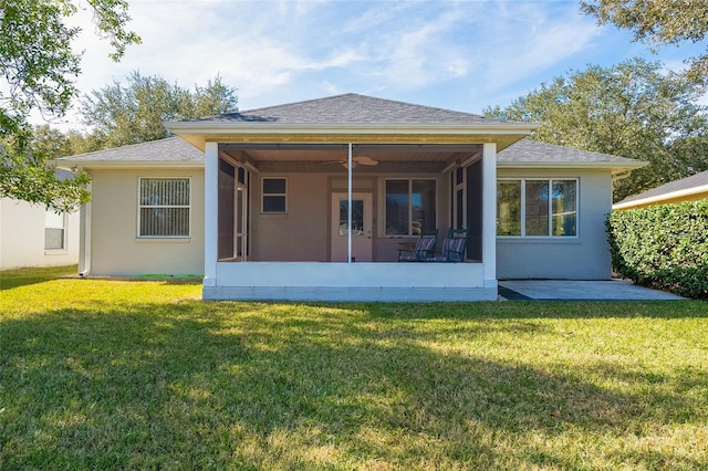 rear view of property with a lawn, a sunroom, and ceiling fan