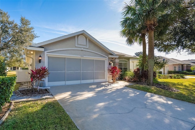 ranch-style house with stucco siding, an attached garage, and driveway