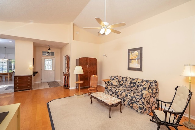 living room featuring a healthy amount of sunlight, baseboards, lofted ceiling, and wood finished floors