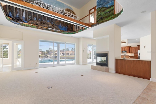 carpeted living room with a high ceiling and a fireplace