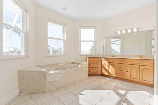 bathroom with a wealth of natural light, tile patterned floors, tiled tub, and vanity