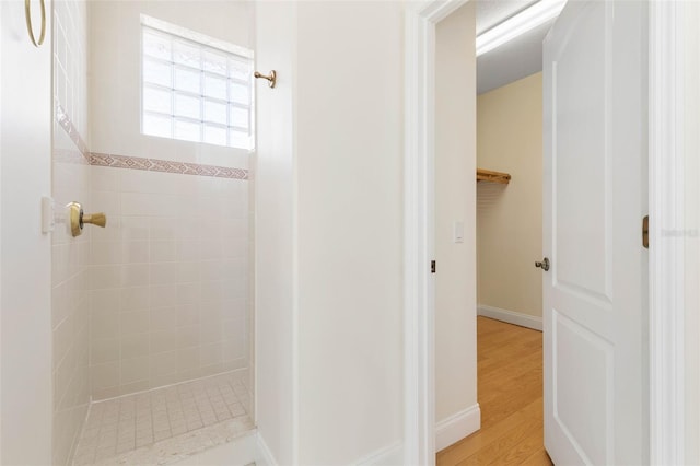 bathroom featuring hardwood / wood-style flooring and tiled shower