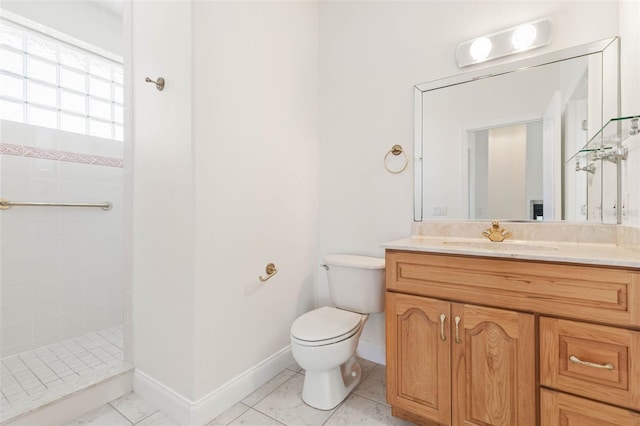 bathroom with tile patterned floors, toilet, tiled shower, and vanity