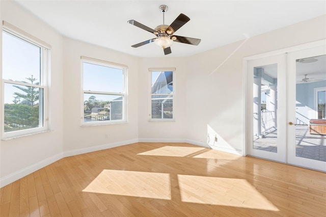 empty room featuring ceiling fan, hardwood / wood-style floors, and french doors