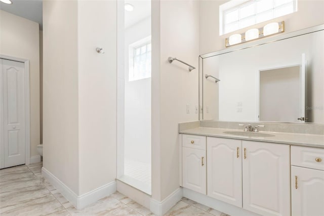 bathroom featuring walk in shower, vanity, plenty of natural light, and toilet