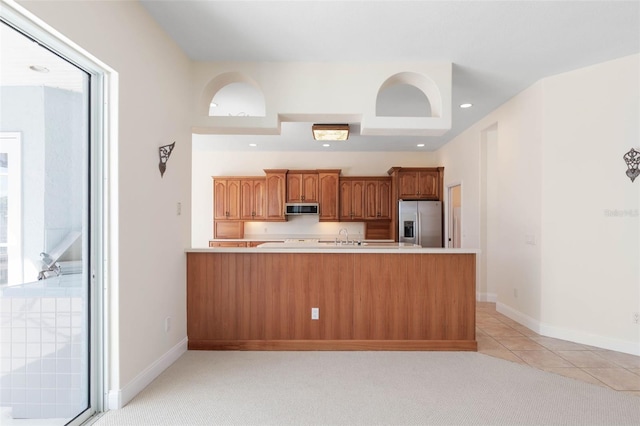 kitchen featuring light tile patterned floors, appliances with stainless steel finishes, kitchen peninsula, and sink