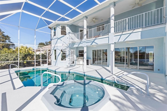 view of swimming pool with glass enclosure, ceiling fan, a patio area, area for grilling, and an in ground hot tub