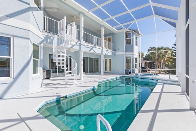 view of swimming pool with ceiling fan, a patio, and an in ground hot tub