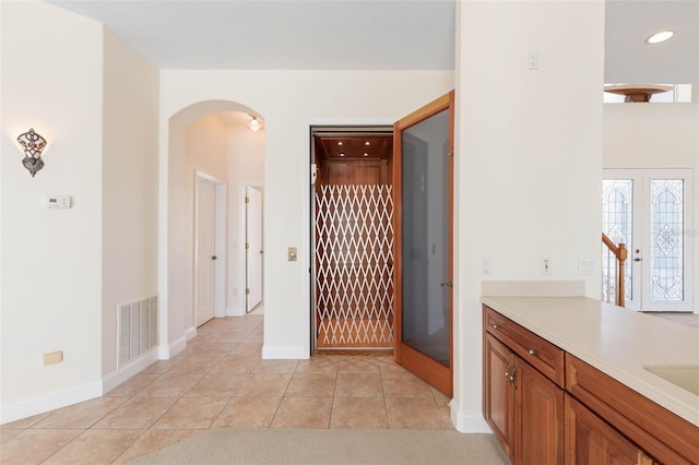 bathroom with vanity, french doors, and tile patterned floors