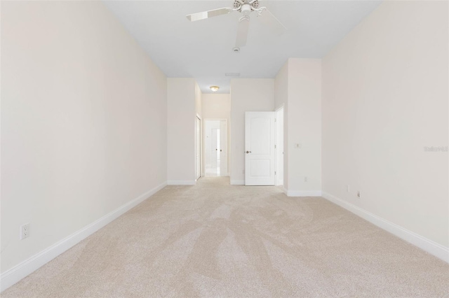 empty room with ceiling fan and light carpet