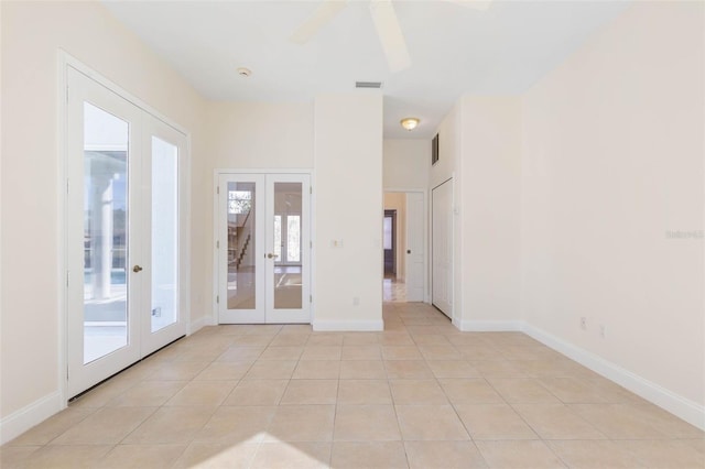 empty room featuring ceiling fan, french doors, and light tile patterned flooring