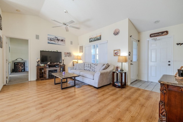 living room with ceiling fan, light hardwood / wood-style floors, and lofted ceiling