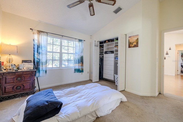 carpeted bedroom with ceiling fan, lofted ceiling, and a closet