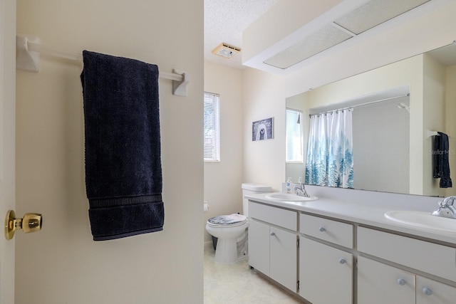 bathroom featuring vanity, toilet, and a textured ceiling